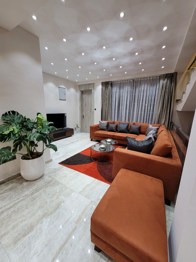 Henrietta Residence living room with sofa, artwork, and glass doors